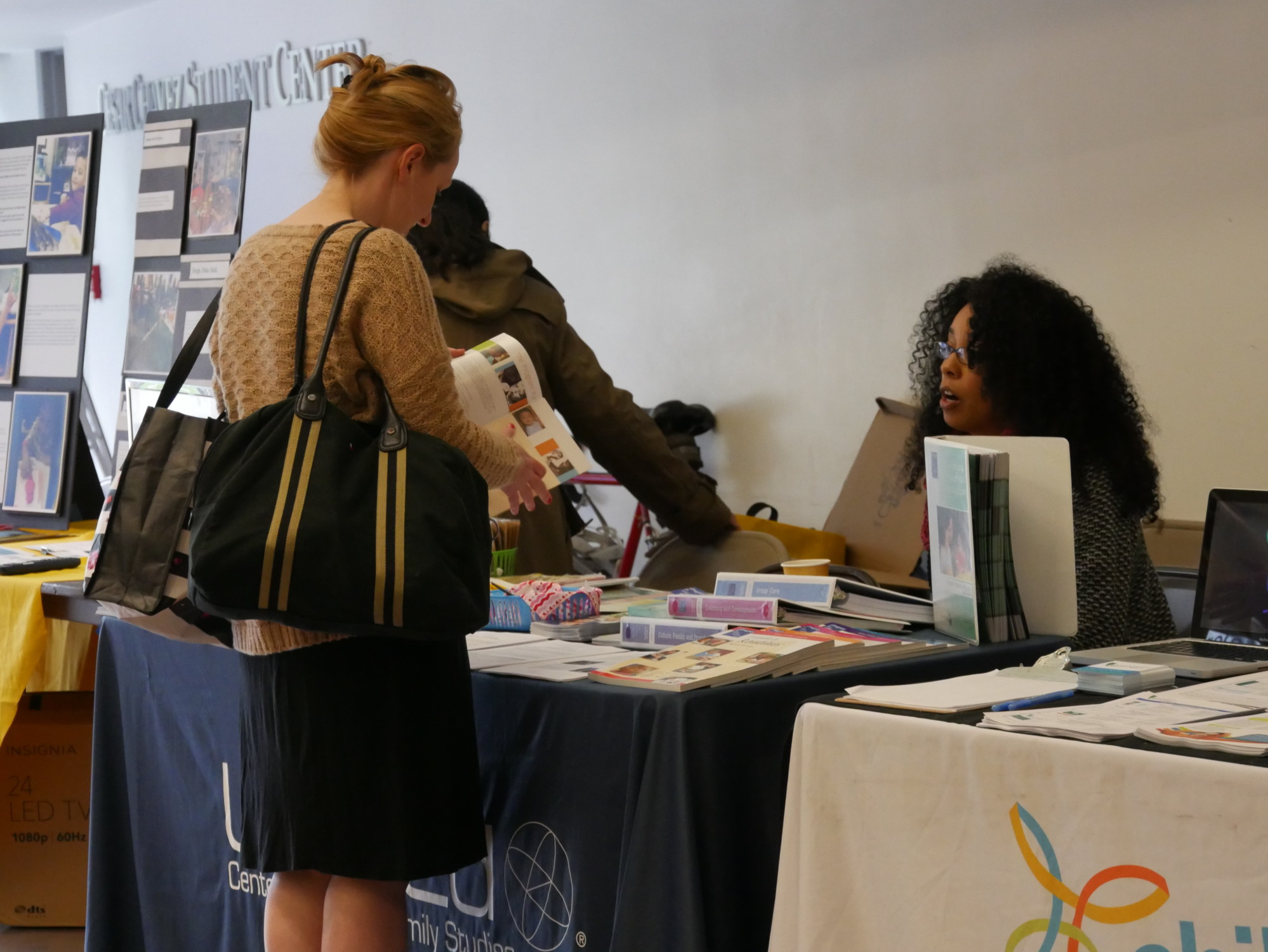 woman signing up and collecting resources at a table
