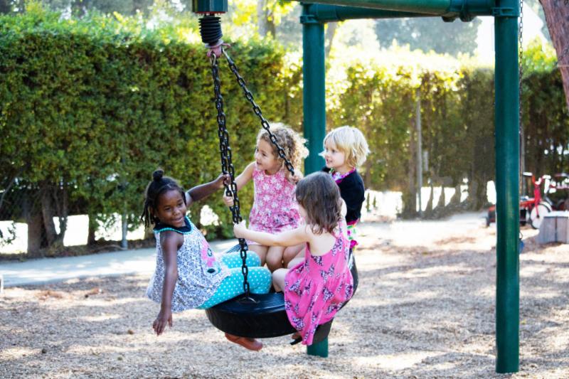 children on tire swing outdoors